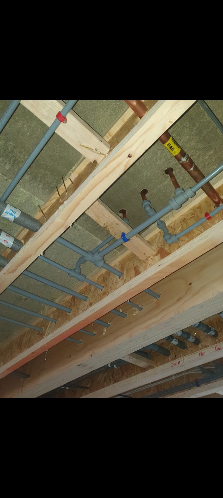 First fix plumbing under floor joists with hot, cold and gas pipework